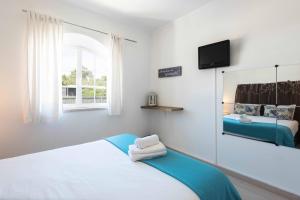 a bedroom with a bed and a tv on the wall at Sesimbra Stylish Villa by Homing in Sesimbra