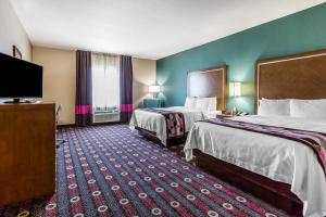 a hotel room with two beds and a flat screen tv at Comfort Inn & Suites Newcastle - Oklahoma City in Newcastle