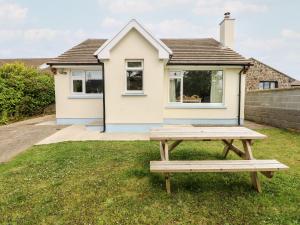 a picnic table in front of a house at Chalfonts Cottage in Haverfordwest