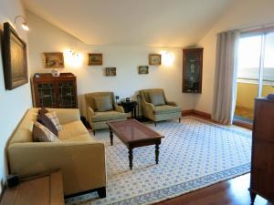 uma sala de estar com um sofá e duas cadeiras e uma mesa em Finest Rentals - Beachfront Penthouse no Funchal