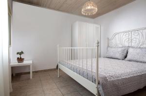 a white bedroom with a bed and a table at Agrikia tis Vasilikis in Ormília