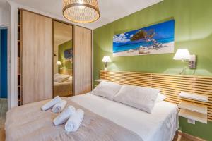 um quarto com uma cama grande com duas toalhas em Appartement Thiers - Welkeys em Antibes
