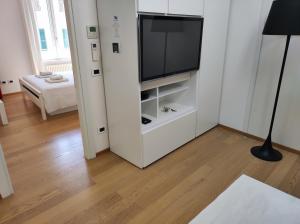 a living room with a flat screen tv on a white wall at Santa Marta Rooms in Vernazza