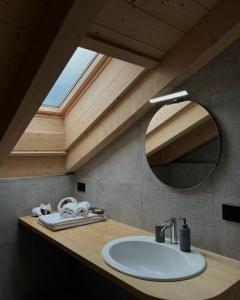 a bathroom with a sink and a mirror on a counter at B&B La Casa del Sole in Ziano di Fiemme