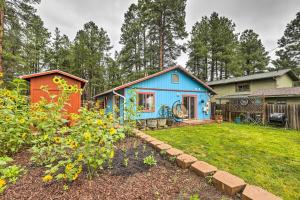 a blue house with a garden in the yard at Forested Flagstaff Getaway with Garden and Gas Grill in Mountainaire