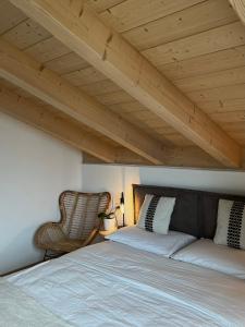 a bedroom with a bed and a chair in a room at B&B La Casa del Sole in Ziano di Fiemme