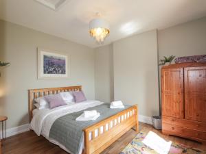 1 dormitorio con cama y tocador de madera en Ceol-na-Mara, 