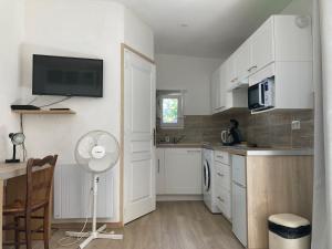 a kitchen with white cabinets and a fan at Appartement maisonnette de vacances in Cannes