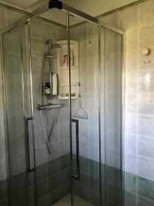 una doccia con porta in vetro in bagno di Cascina 'La Giardina' a Fossano