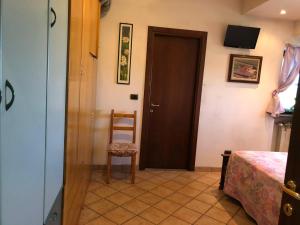 a room with a door and a chair and a bedroom at Cascina Giardina in Fossano +3 photos