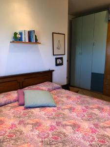 una camera da letto con un letto con un cuscino sopra di Cascina 'La Giardina' a Fossano