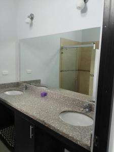 uma casa de banho com 2 lavatórios e um espelho grande em Playa Tamarindo, CasaMar de Tamarindo em Tamarindo