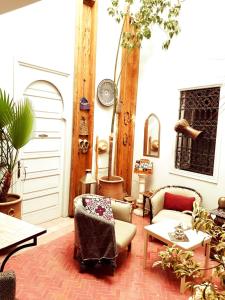 a living room with two chairs and a table at Riad Laly Tourisme Eclairé Le bijou de la medina in Marrakesh