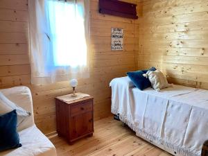 a bedroom with two beds and a window and a table at Dos VILLAS ENTRE CIERVOS Y CERVANTES in El Cristo del Espíritu Santo