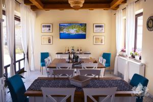 a dining room with a table and blue chairs at Érintés Vendégház in Tállya
