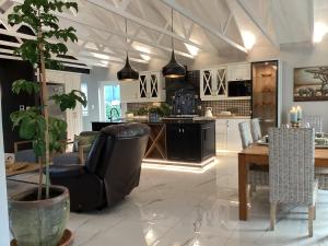 a living room with a chair and a table and a kitchen at Villa Lyrique in Cape Town