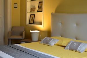 a bedroom with a bed with two pillows and a chair at queen 24 in Taranto