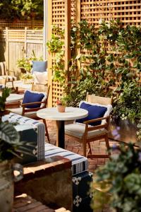 a patio with chairs and tables and plants at Blue Iris by Life House in Nantucket