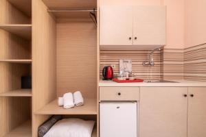 a kitchen with wooden cabinets and a white refrigerator at Aza Studios in Laganas