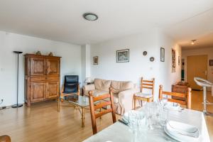 ein Wohnzimmer mit einem Tisch und einem Sofa in der Unterkunft Appartement Georges - Welkeys in La Rochelle