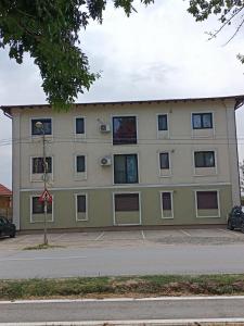 un bâtiment jaune avec des fenêtres sur une rue dans l'établissement Apartament Ovidiu, à Giroc