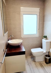 a bathroom with a sink and a toilet and a window at Acogedor apartamento a la entrada de camino portugués in Santiago de Compostela