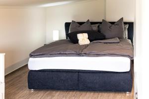een slaapkamer met een groot bed met zwarte kussens bij Ferienwohnung Alwine in Goslar