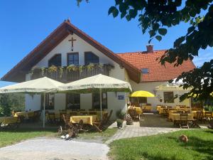 a restaurant with tables and umbrellas in front of a building at Trautenburg Stub`n in Leutschach