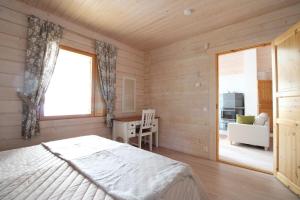 - une chambre avec un lit, un bureau et une fenêtre dans l'établissement Villa Lilian, à Ähtäri