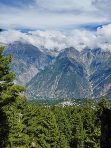 - une vue sur une chaîne de montagnes avec des arbres et des nuages dans l'établissement THE BLISS HOME STAY, à Kalpa