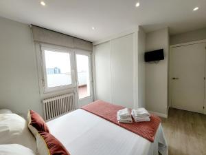 Un dormitorio con una gran cama blanca y una ventana en Acogedor apartamento a la entrada de camino portugués, en Santiago de Compostela