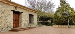a stone building with a wooden door and a street light at Finca La Celada in Moratalla