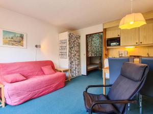 ein Wohnzimmer mit einem rosa Sofa und einem Stuhl in der Unterkunft Studio Flaine, 1 pièce, 4 personnes - FR-1-425-164 in Flaine