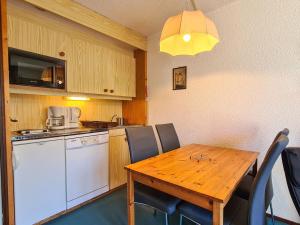 eine Küche mit einem Holztisch mit Stühlen in der Unterkunft Studio Flaine, 1 pièce, 4 personnes - FR-1-425-164 in Flaine