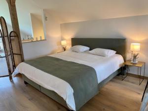 a bedroom with a large bed with two tables and two lamps at Deurles Moment in Sint-Martens-Latem