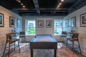 a room with a ping pong table and chairs at Contemporary flat at The Maddox in Nashville