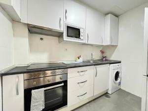 a kitchen with white cabinets and a microwave at Ile Aina Exterior in Madrid