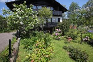 a house with a garden of flowers in front of it at Haus Buron in Titisee-Neustadt