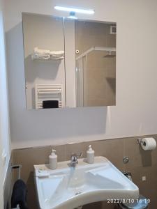 W łazience znajduje się biała umywalka i lustro. w obiekcie Piano Nobile w mieście Napoli