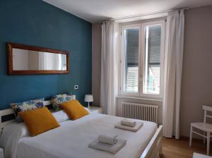 a white bed sitting in a bedroom next to a window at Santa Marta Rooms - Via Roma 23 in Vernazza