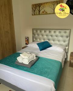 a bedroom with a bed with towels on it at Apartasol Villa Rosa, Reserva de la Colina, La Tebaida, Quindio in La Tebaida