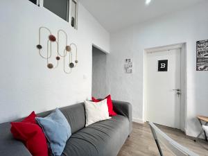 a living room with a gray couch with red pillows at Ile Aina Exterior in Madrid