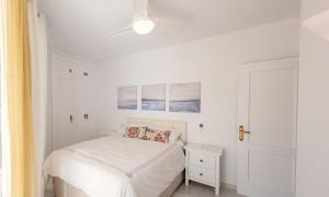 1 dormitorio blanco con 1 cama y ventilador de techo en Penthouse with terrace in Marbella- Costa del Sol, en Marbella