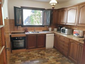 a kitchen with wooden cabinets and a sink and a window at Beau F4 petreto-Bicchisano in Petreto-Bicchisano +8 photos