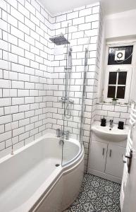 a white bathroom with a tub and a sink at Trustay Serviced Apartments - Shoreditch in London