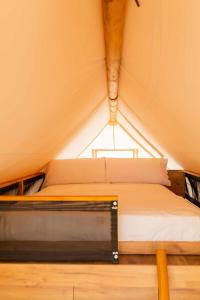 a bed in a tent with a window at wecamp Cabo de Gata in Las Negras