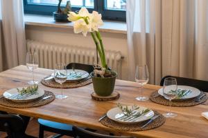 una mesa de madera con un jarrón con una flor. en Kleines charmantes Haus am See, en Dießen am Ammersee