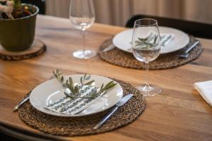 una mesa de madera con platos y copas de vino en Kleines charmantes Haus am See, en Dießen am Ammersee