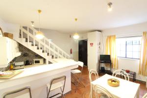 a living room with a staircase and a table and chairs at Fisherman's Townhouse at Old Town in Albufeira