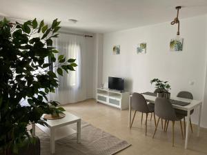 uma sala de estar com uma mesa e cadeiras e uma televisão em Increíble apartamento en pleno centro de Arrecife em Arrecife